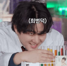 a man in a lab coat is smiling while looking at test tubes with korean writing on them
