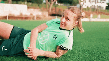 a woman in a green shirt with the letter w on it
