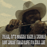 a man in a cowboy hat is holding a bow and arrow and says yeah it 's gonna