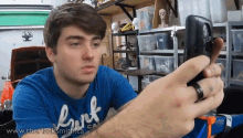 a man wearing a blue shirt that says hart is taking a picture of himself