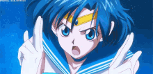 sailor mercury from sailor moon is making a peace sign with her hands in the air .