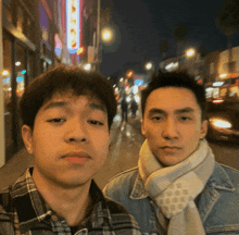 two young men are posing for a picture in front of a sign that says ' abc '