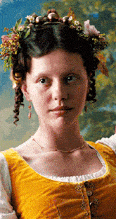 a woman wearing a yellow top and a flower crown on her head