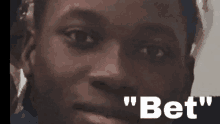 a close up of a man 's face with the words " bet " written below him