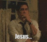 a man in a white shirt and black tie says jesus while covering his mouth
