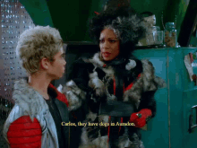 a man and a woman are standing next to each other and the woman is saying carlos they have dogs in auradon