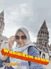 a woman wearing sunglasses stands in front of a temple with the words waalaikum salam written on the bottom