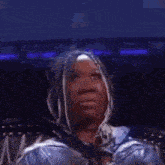 a woman is sitting in a chair and making a funny face while looking at the camera .