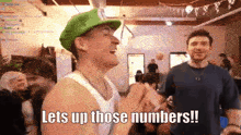 a man wearing a green hat says let 's up those numbers !