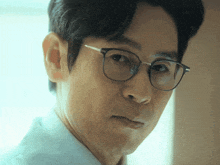 a close up of a man wearing glasses and a white shirt