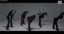 a group of people in suits are doing a dance routine with the k logo in the corner
