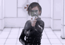 a man with a green mask on his face is pointing a gun at the camera