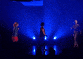 a girl singing into a microphone and a man dancing on a stage with blue lights