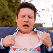 a man in a suit is taking off his shirt and saying oh my god .