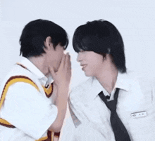 two men are whispering into each other 's ear .