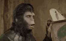 a monkey is looking at a picture of a foot in a box .