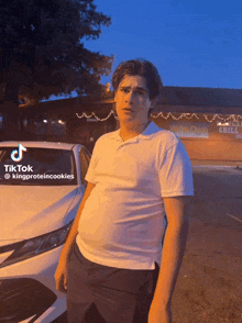 a man standing in front of a white car with tiktok written on the bottom