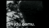 a black and white photo of a man with the words jdu domu in white letters