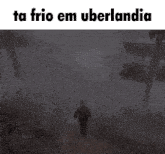 a man walking in the fog with the text ta frio em uberlandia