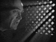 a man is looking through a window with squares on it