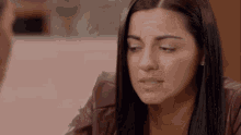 a woman in a leather jacket is looking at a man .