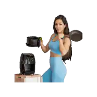 a woman in a blue top is holding a frying pan and an air fryer
