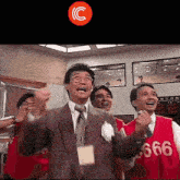 a man in a suit and tie is wearing a red vest with the number 6666 on it .