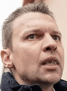 a close up of a man 's face with his mouth open and looking up .