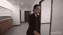 a woman in a black suit is standing in a hallway made by animatica