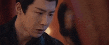a man and a woman are looking at each other in a dark room .