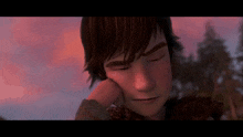 a close up of a boy with his hand on his face