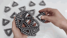 a person is holding a bunch of metal balls in their hand