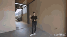 a woman is standing in an empty room with the words made in animatica on the bottom right