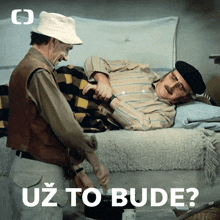 a man kneeling next to a man laying on a bed with the words uz to bude below him