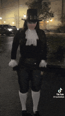 a woman wearing a top hat and white socks is standing on a street