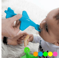 a baby is eating a cookie while holding a toy airplane .