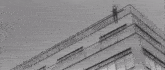 a man is jumping in the air with his arms outstretched in a black and white photo .