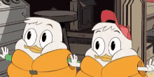 two ducks are standing next to each other in a cartoon .