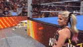 a woman in a wrestling ring with a sign that says killer