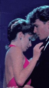 a man and woman are dancing and the woman is wearing a red dress