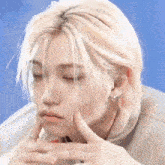 a close up of a person 's face with their hands on their chin .