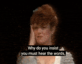 a woman is crying on a stage and covering her face with her hands .