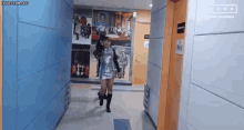 a woman in a sequined dress is walking down a hallway .