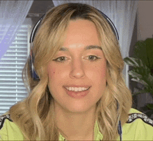 a woman wearing headphones and a neon yellow jacket smiles