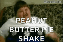 a man is sitting on a couch with a peanut butter pie shake .