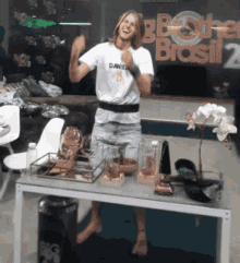 a man wearing a shirt that says daniel is standing in front of a table