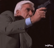 a man in a suit is pointing a gun at something