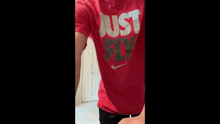 a man is wearing a red nike shirt that says just fly