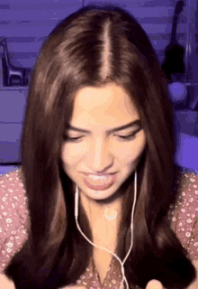 a close up of a woman wearing headphones and making a face