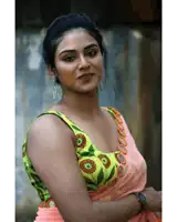 a woman is wearing a green and orange blouse with the words moviegallery.net on the bottom